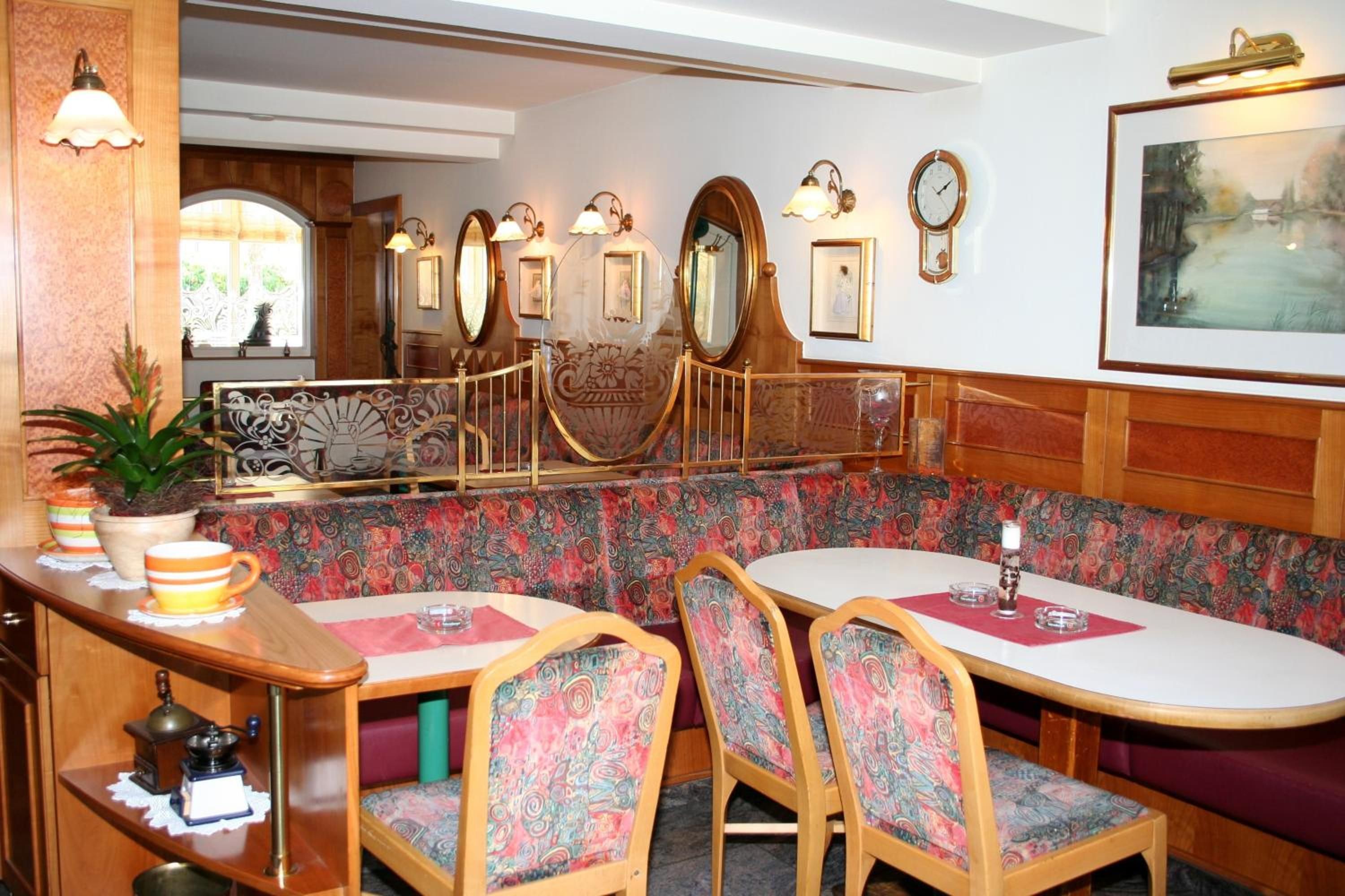 Ein Restaurant mit einer Sitzecke in einer Box, Holzmöbeln und Wanduhren.