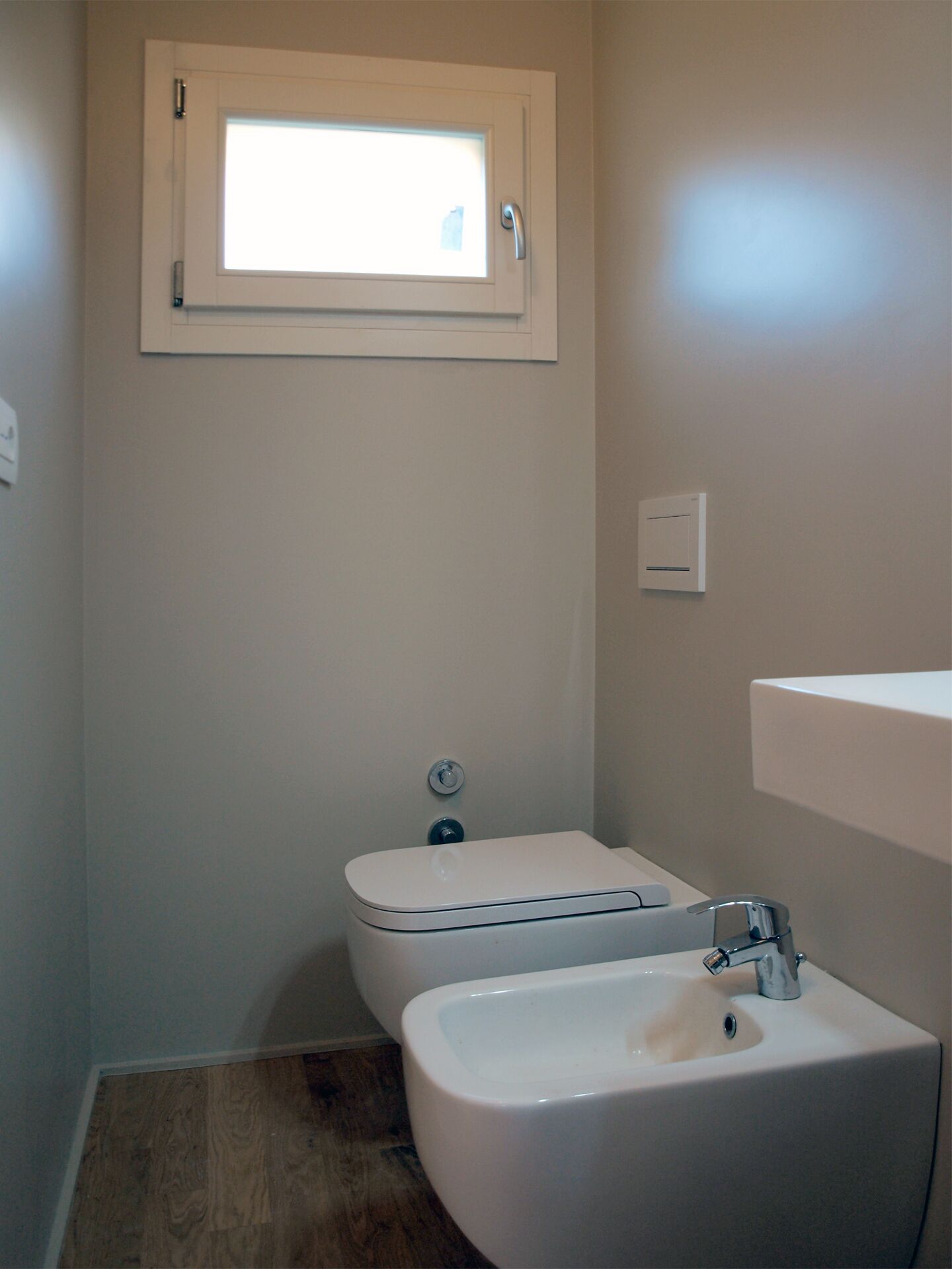 A small bathroom with a toilet, bidet, and sink.