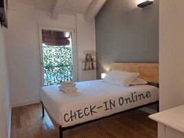 Et soveværelse med en seng, et vindue med udsigt og et skilt, der viser 'CHECK-IN Online' på sengen.