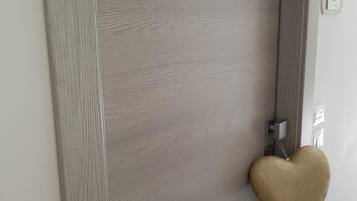 Una puerta con acabado gris texturizado y un llamador con forma de corazón.
