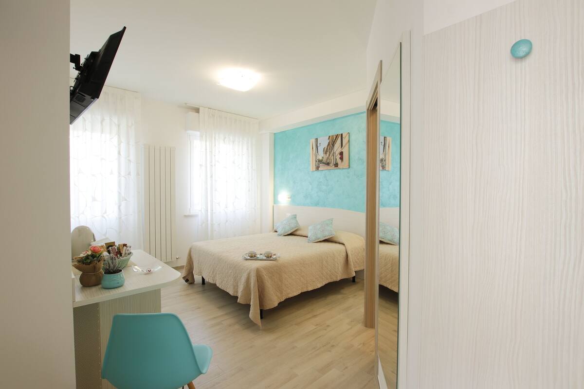Quarto com cama, mesa de cabeceira e uma cadeira.