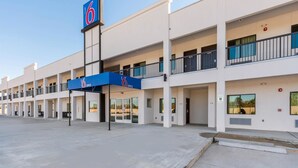 A 6 Office hotel with a modern design, featuring multiple floors, balconies, and a clear sky. - Motel 6 Channelview, TX (Channelview)