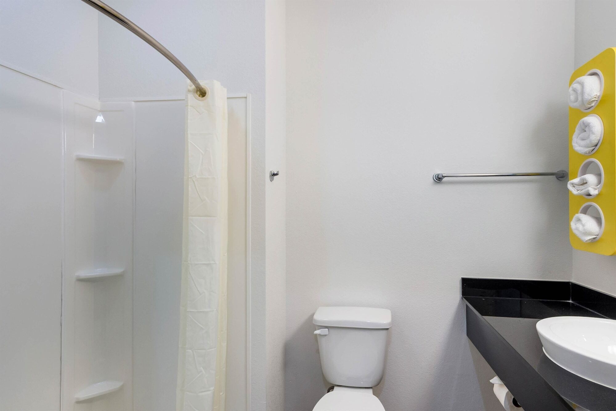 A bathroom with a toilet, a sink, and a shower area.