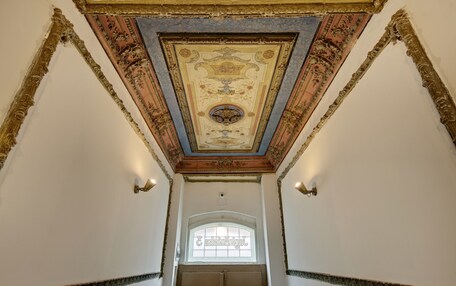An ornate ceiling with intricate designs and a central circular medallion.