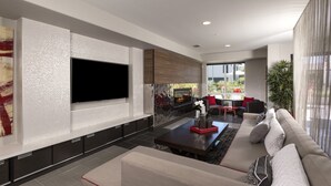 Una sala de estar moderna con un televisor de pantalla plana, una chimenea, un sofá y una mesa de centro.