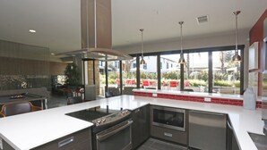 Una cocina moderna con una isla central, horno empotrado y electrodomésticos de acero inoxidable.
