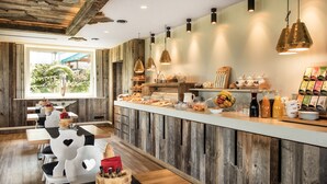 Una barra de desayuno con paneles de madera, lámparas colgantes y una variedad de alimentos para el desayuno.