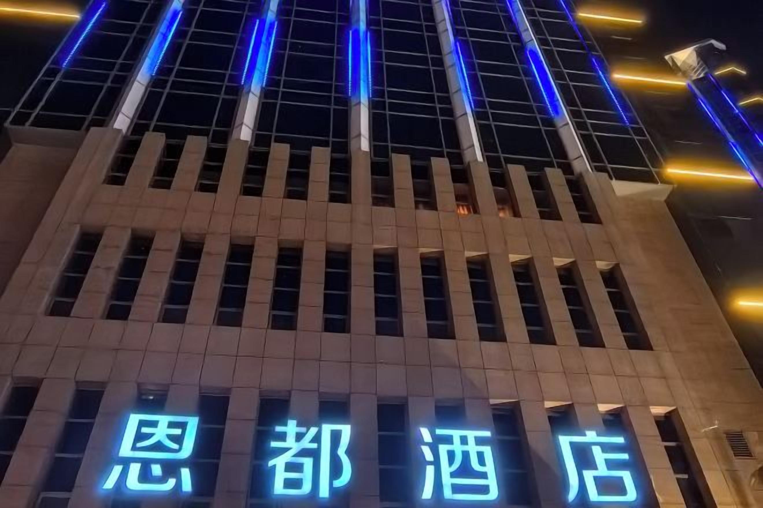 Un edificio con insegne illuminate che indicano un albergo.