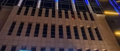 Un edificio con letreros iluminados que indican un hotel.