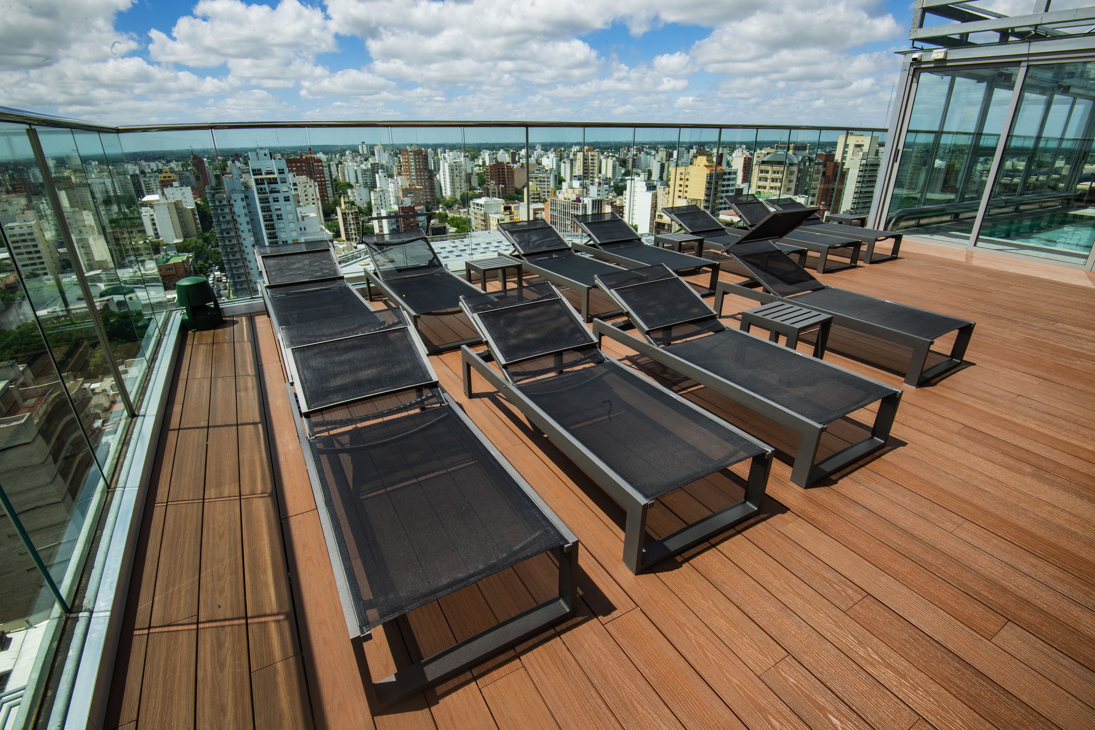 A rooftop terrace with sun loungers and a city view.