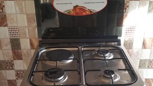 A kitchen with a stove and a sign indicating it is designed in Italy. - Perfect Home Two minutes to Kijiji Beach (Dar es Salaam)