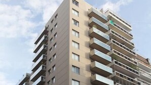 A multi-story building with balconies, a storefront, and a sign for 'Medical Workers'. - ARC Callao Studios & Suites (Buenos Aires)
