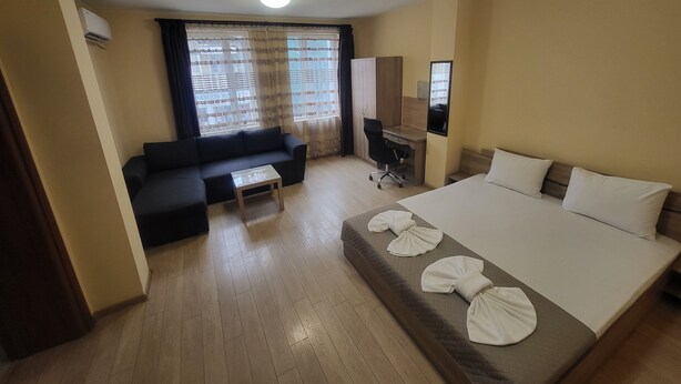 Ein Hotelzimmer mit Bett, einer Couch, einem Schreibtisch und einem Sessel.