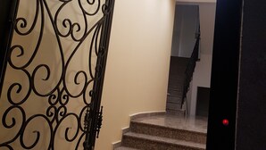 Eine Treppe mit schmiedeeisernem Geländer, das zu einer Empore führt.