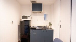 A compact kitchen with a refrigerator, microwave, and sink. - East Shinagawa Apartment (Tokyo)