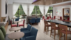A modern dining area with tables and chairs, large windows with curtains, and a kitchen area.