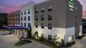 A Holiday Inn Express building with a modern design, featuring a covered entrance and a parking area.