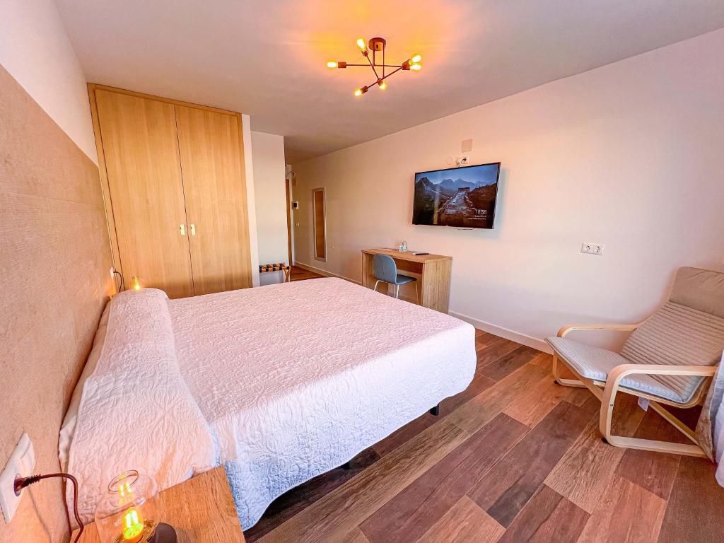Un dormitorio con cama, escritorio, silla y armario.