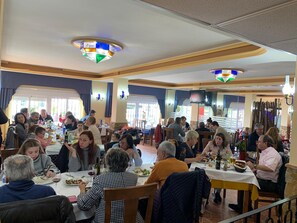 A restaurant with multiple tables and patrons dining. - Hostal Sorbas (Sorbas)