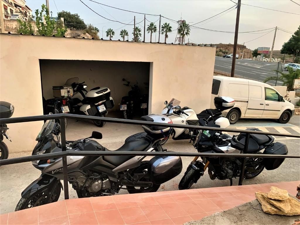 A motorcycle parked in front of a building with a garage.