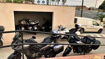 A motorcycle parked in front of a building with a garage.