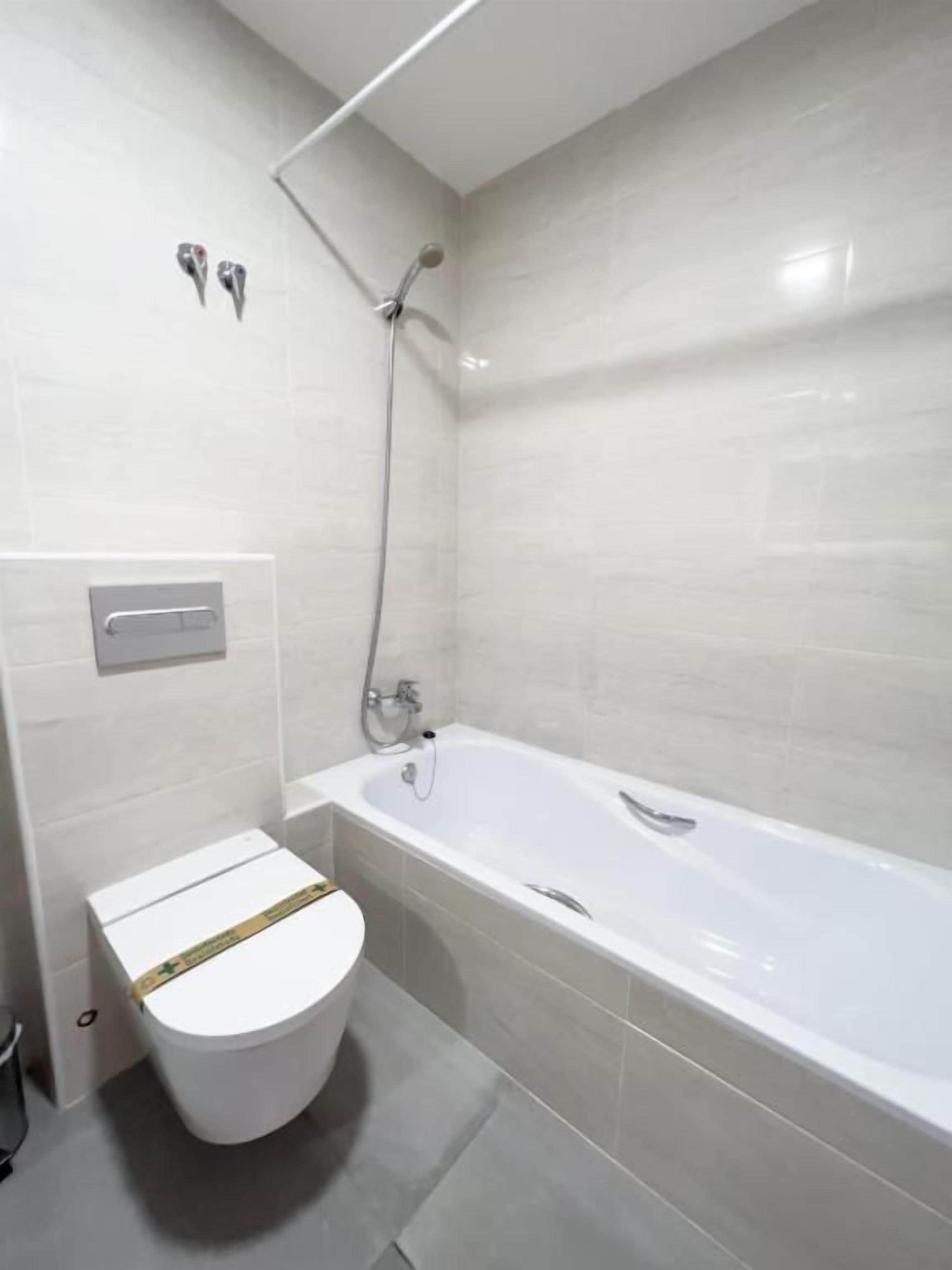 Un baño con inodoro blanco, bañera y ducha.