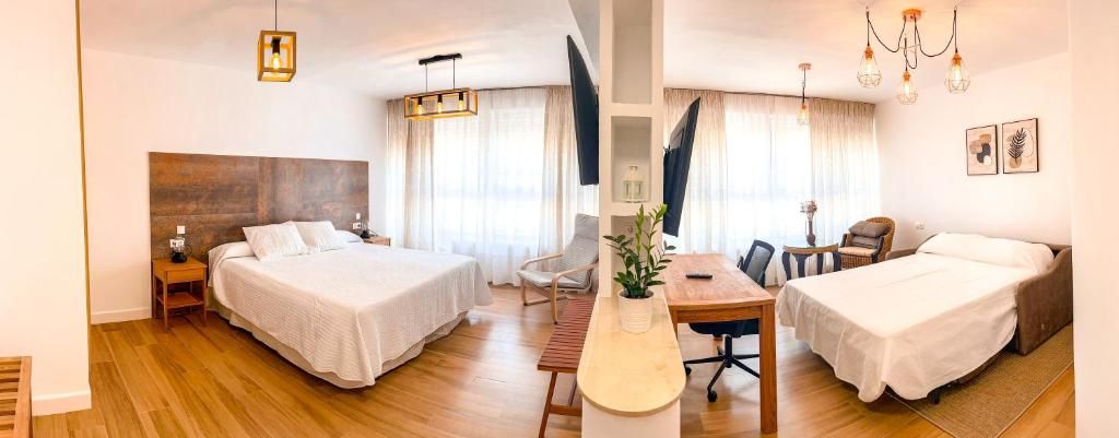 A hotel room with two beds, a desk, and a chair.