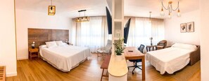 A hotel room with two beds, a desk, and a chair. - Hostal Sorbas (Sorbas)