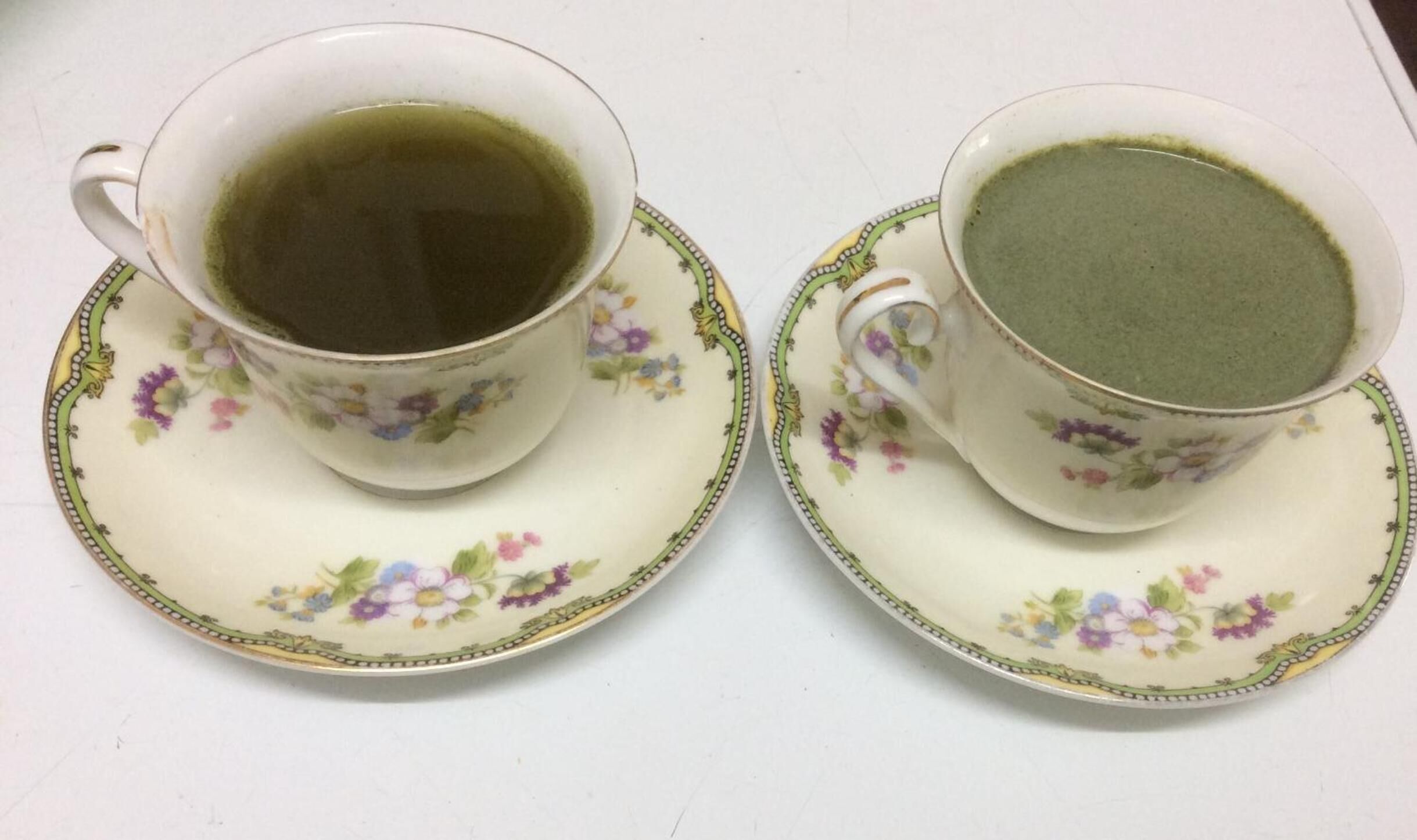 Twee kopjes thee op bijpassende schoteltjes met bloemenmotieven.