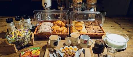 A breakfast buffet with various food items, coffee, and condiments.
