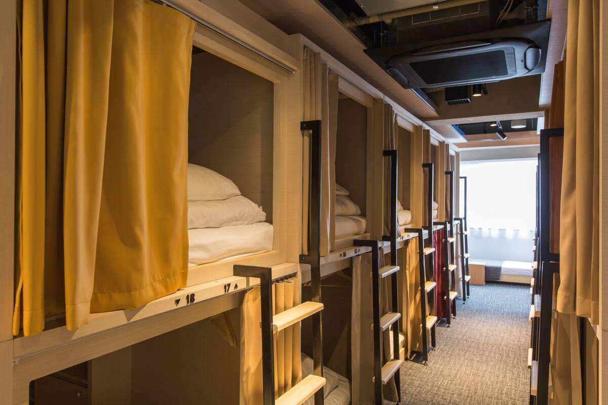 A train compartment with bunks, curtains, and a window.
