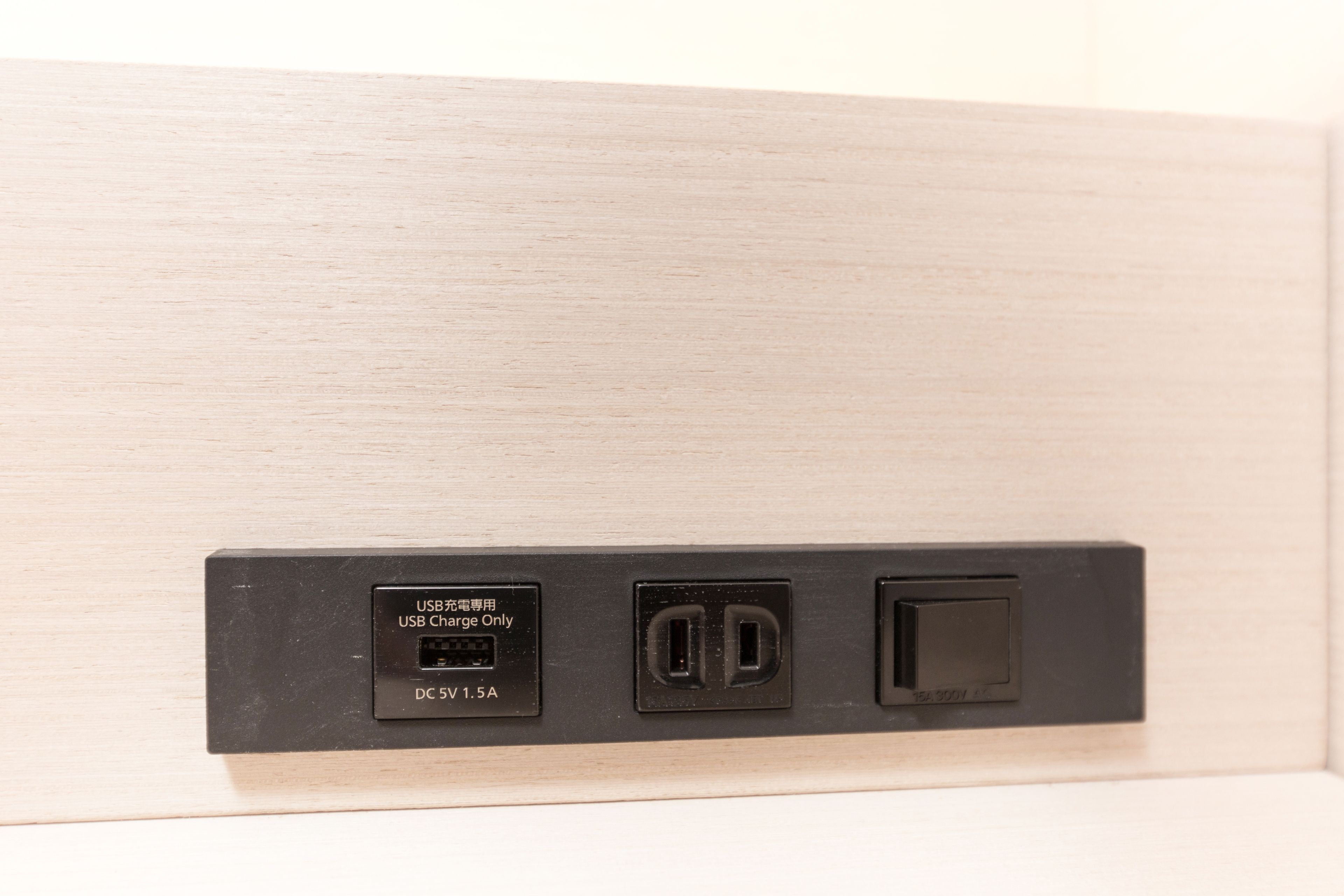 A wall-mounted electrical outlet with a USB charging port, a standard electrical outlet, and a switch.