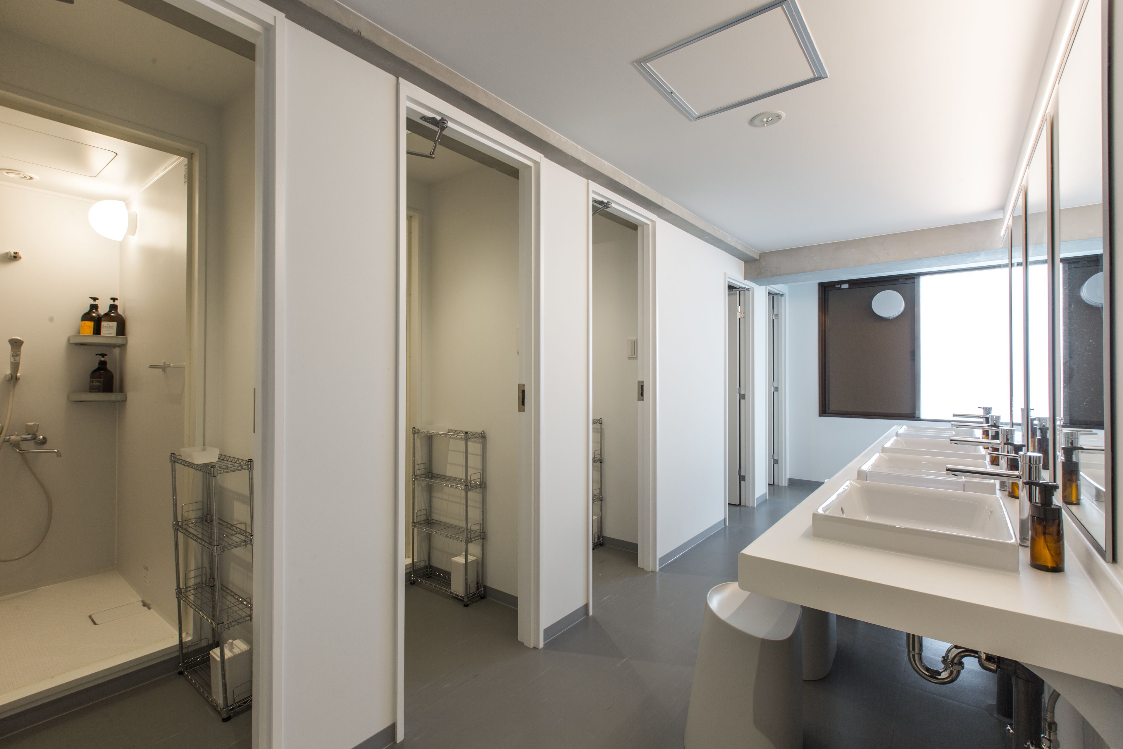 A modern bathroom with a walk-in shower, a vanity with two sinks, and a large mirror.