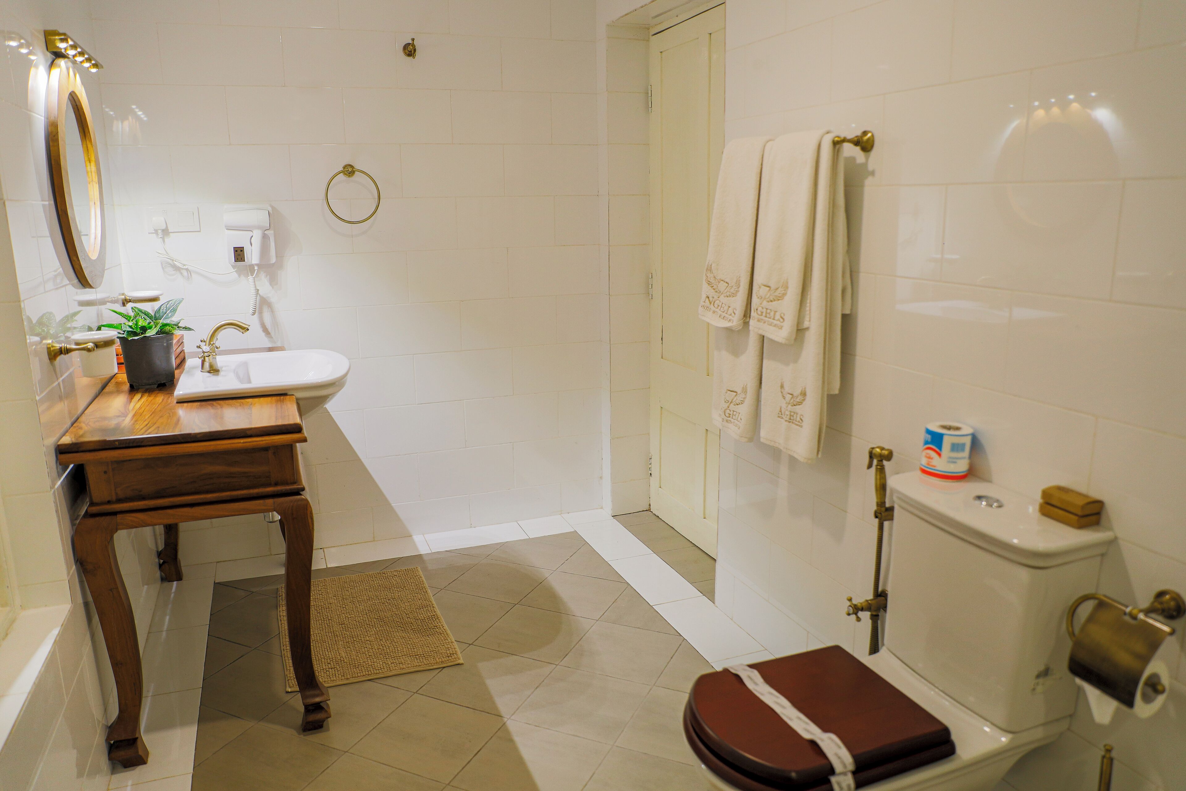 A bathroom with a wooden vanity, a sink, a toilet, and a shower area.
