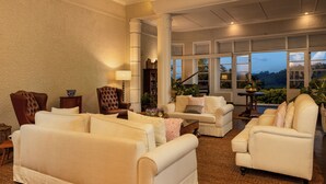 A spacious living room with multiple sofas and armchairs, a coffee table, and a large window with a view of the outdoors. - Castle Hill Bungalow by Seven Angels (Kandy)