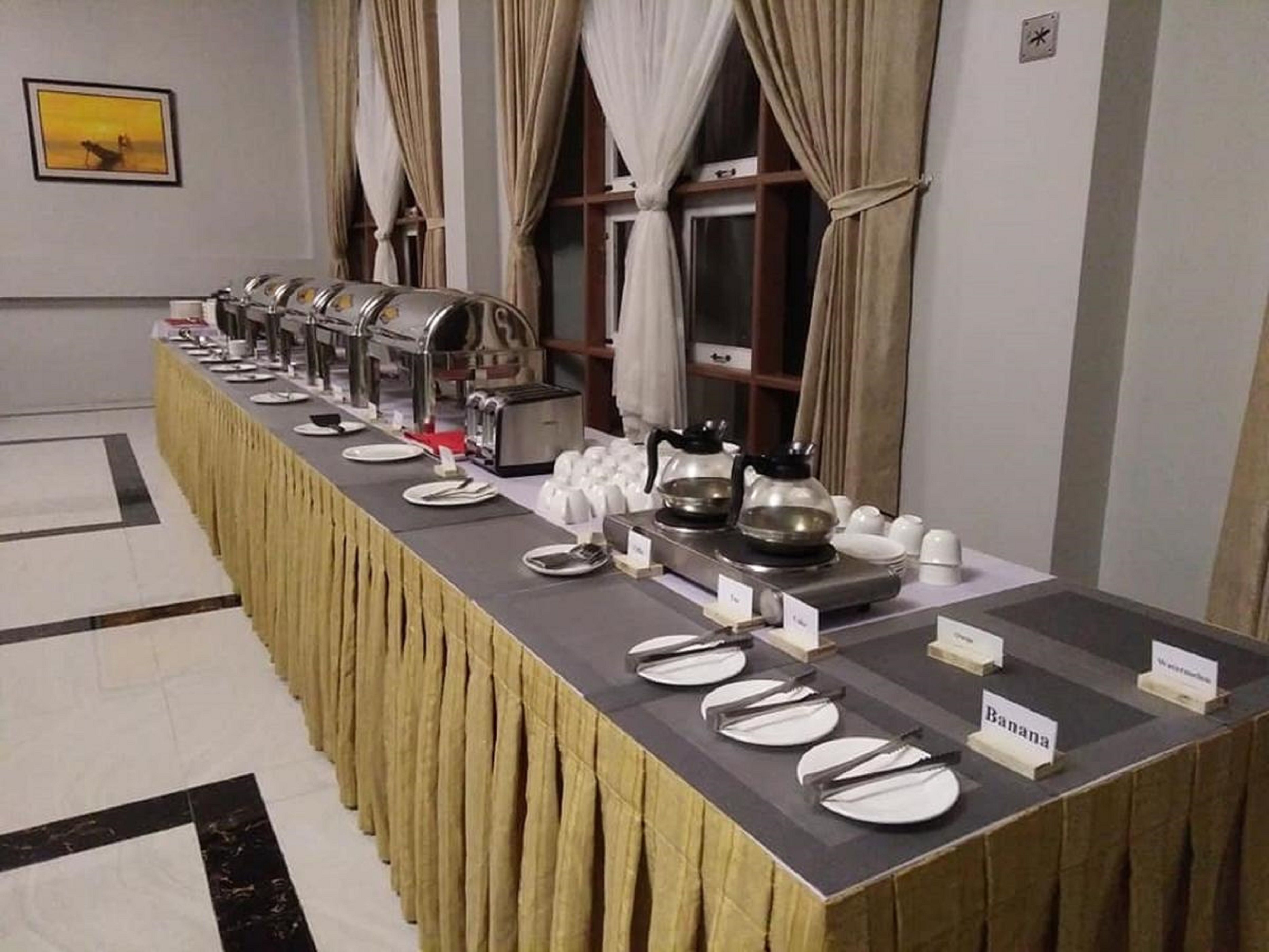 A buffet setup with multiple serving stations, including a coffee station and a designated area for banana dishes.