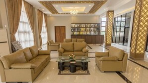 A spacious living area with a central coffee table, two sofas, and a bookshelf. - Hotel Mya Yar Pin (Kalaw)