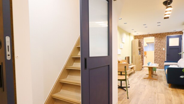 Un interior moderno con una escalera, un comedor y una sala de estar.