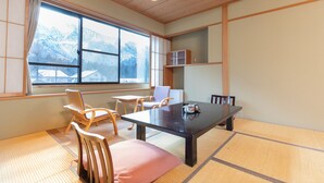 A traditional Japanese room with tatami flooring, a low table, and wooden furniture. - Tabist Kazeyuki (Takayama)