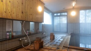 A traditional Japanese onsen with wooden cabinets, a tiled floor, and a wooden bench. - Tabist Kazeyuki (Takayama)