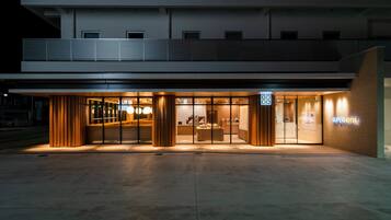 A modern hotel entrance with a reception desk, glass doors, and a sign indicating it is a Superhotel.