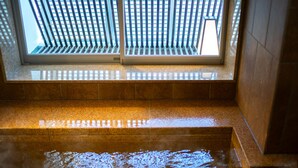 A view of a spa area with a window overlooking a building, a tiled floor, and a water feature. - Super Hotel Yamagata Sakuranbo Higashine Ekimae (Higashine)