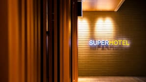 A hallway leading to a room with a sign that reads "SUPERHOTEL". - Super Hotel Yamagata Sakuranbo Higashine Ekimae (Higashine)