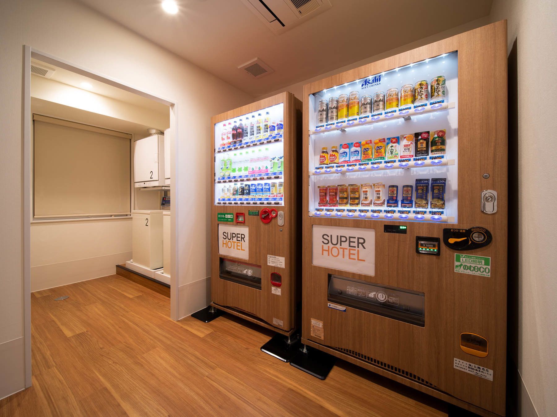 Two vending machines labeled "Super Hotel" with a variety of beverages and snacks.