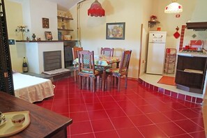 A compact living space with a dining area, kitchen, and a small seating area. - Emanuele Apartments (Ascea)