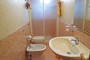 A bathroom with a toilet, bidet, and sink. - Emanuele Apartments (Ascea)