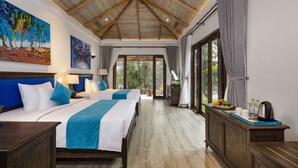 Une chambre spacieuse avec deux lits, un plafond en bois, de grandes fenêtres et une vue sur l’extérieur.