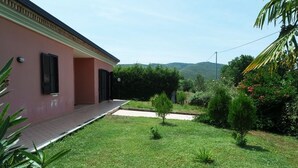 A pink building with a small garden and a paved area. - Villa Kalithea (Montecorice)