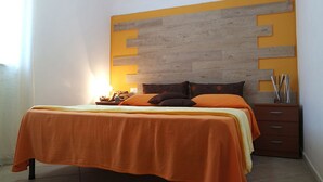 Un dormitorio con una cama, una mesita de noche y un cabecero de madera.
