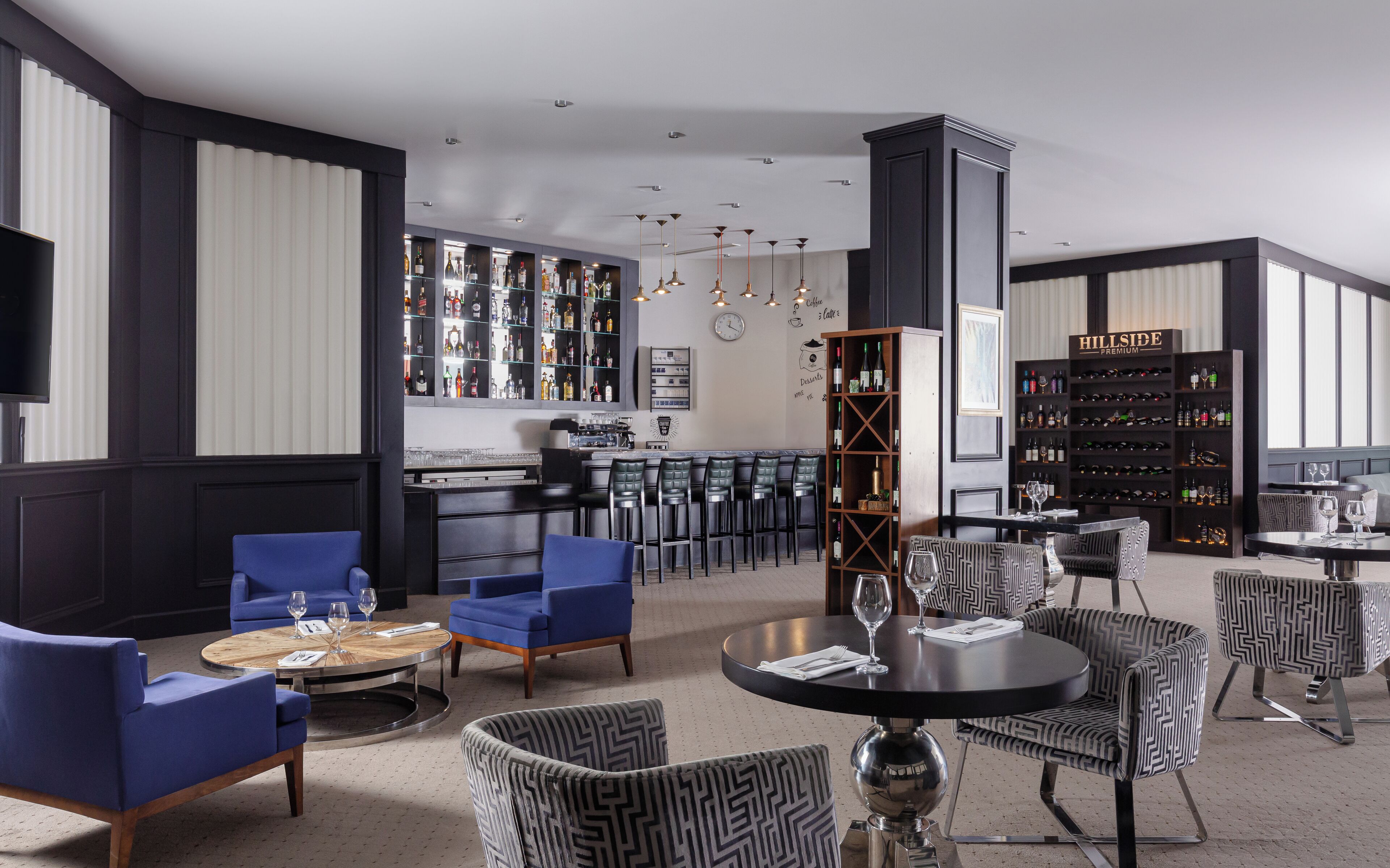 A modern bar area with seating, a wine rack, and a television.